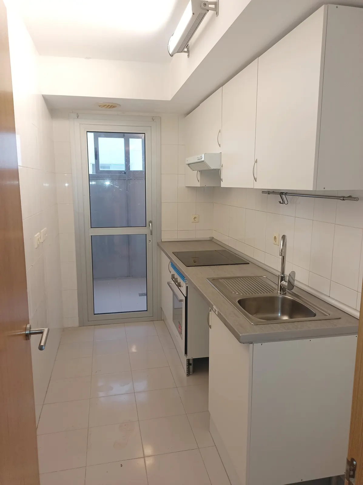 Cocina reformada de principio a fin: muebles, encimera y electrodomésticos.
